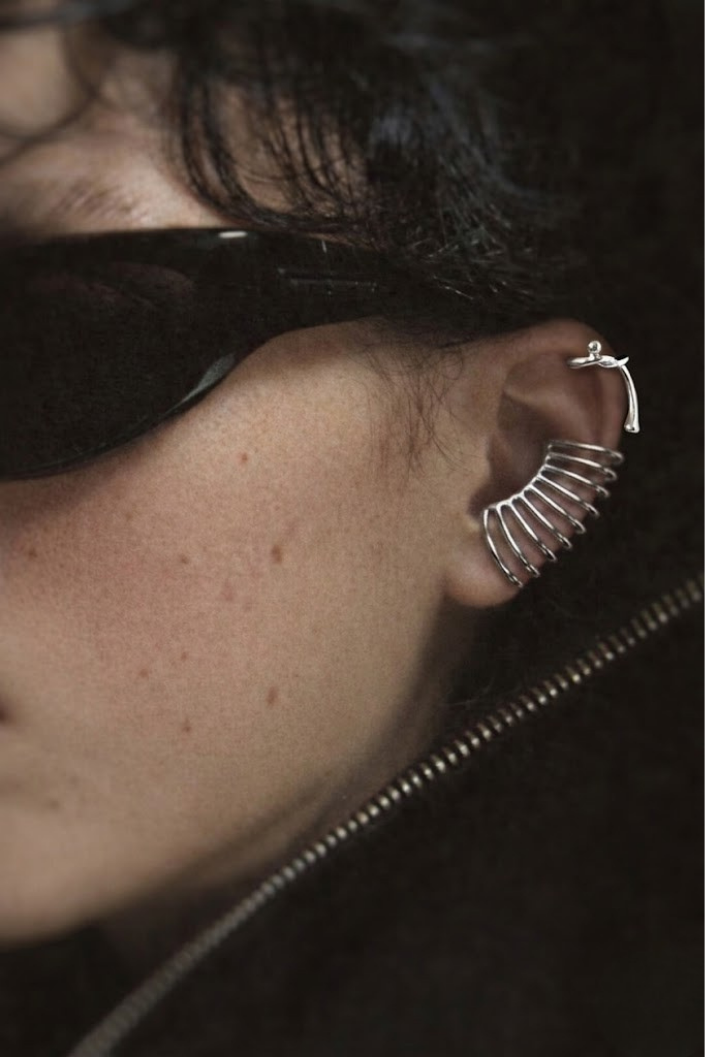 A model wearing a stacked silver ear cuff set without piercings