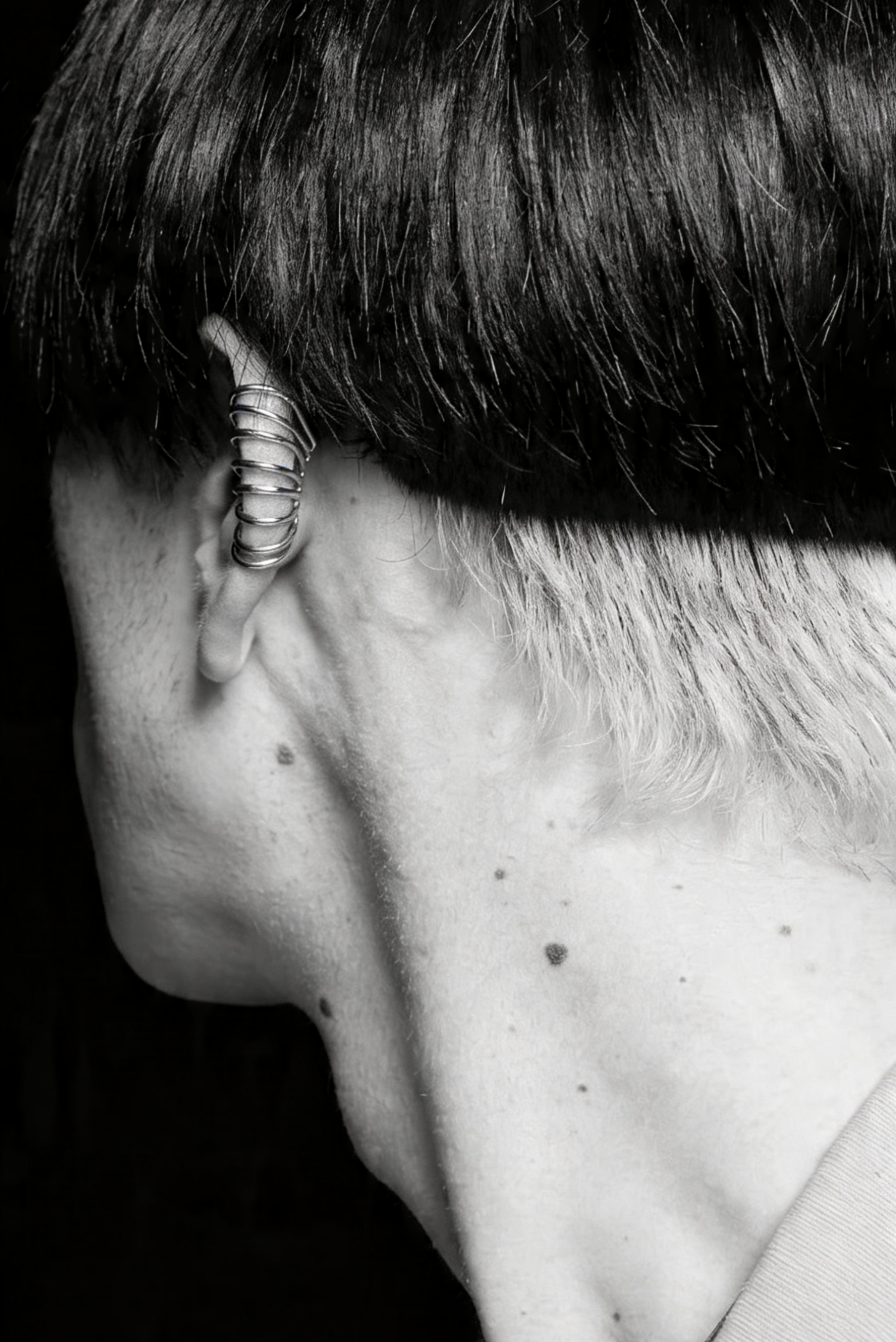 A model wearing a ribbed silver ear cuff without a piercing