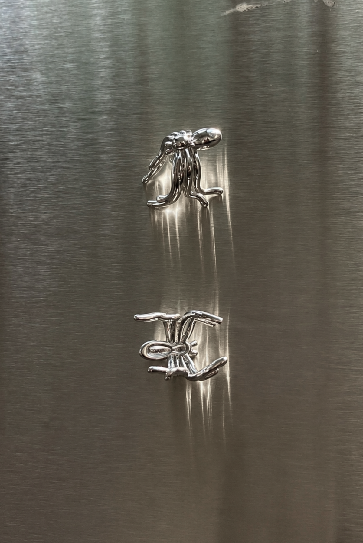 A silver spider ear cuff shown on its own against a plain background