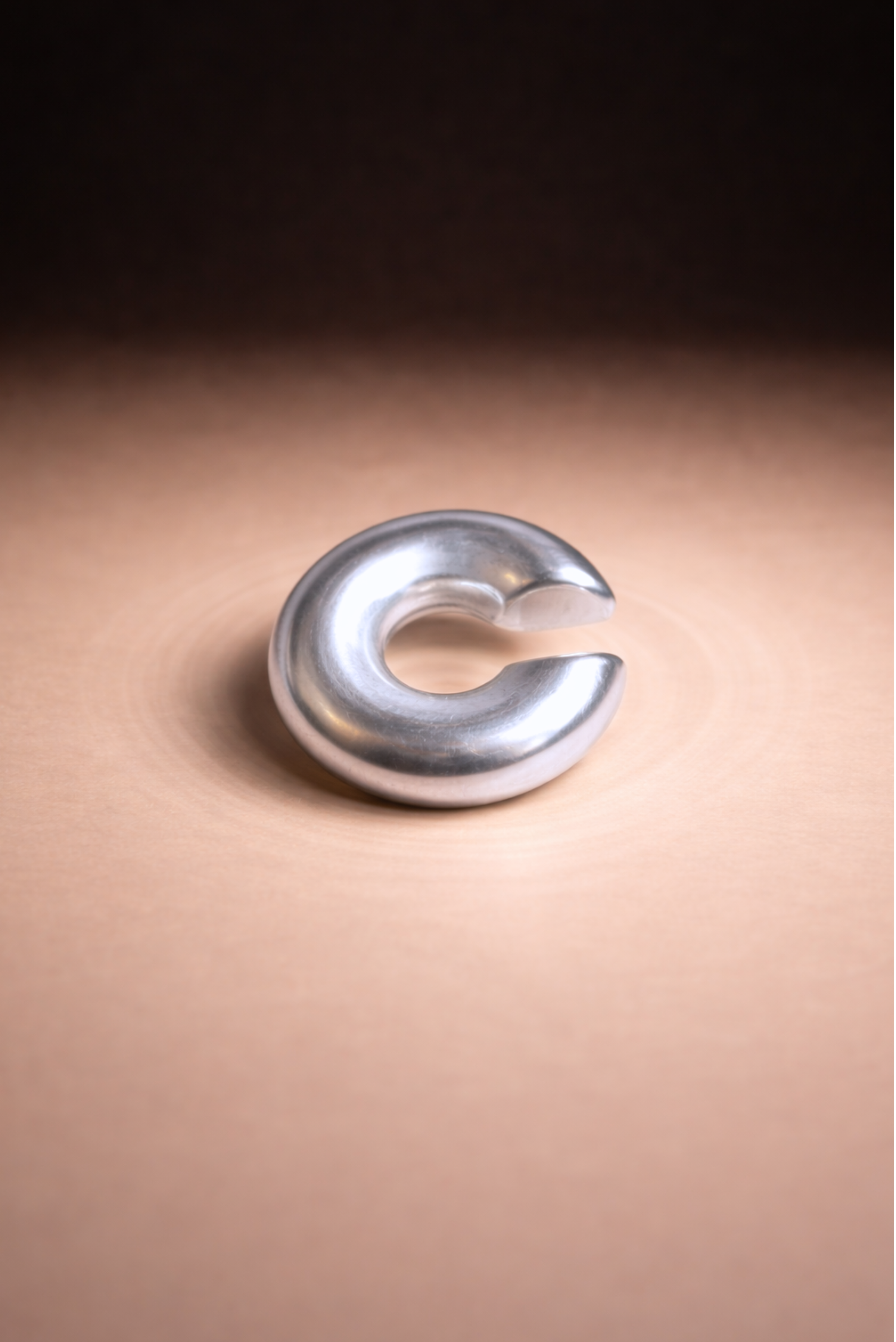 A circular open-hoop ear cuff shown on its own against a plain background