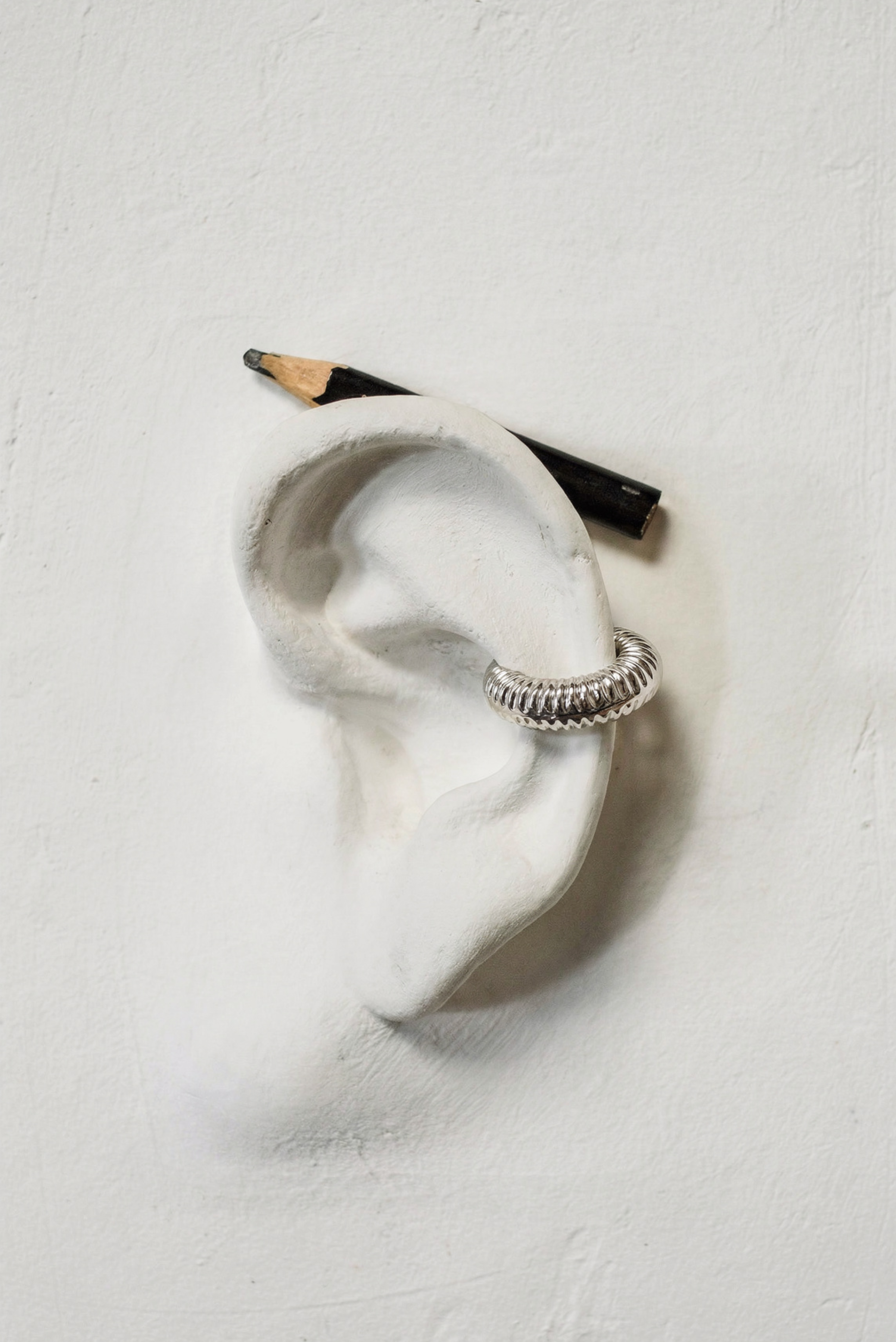 A large bold copper-toned ear cuff shown on its own