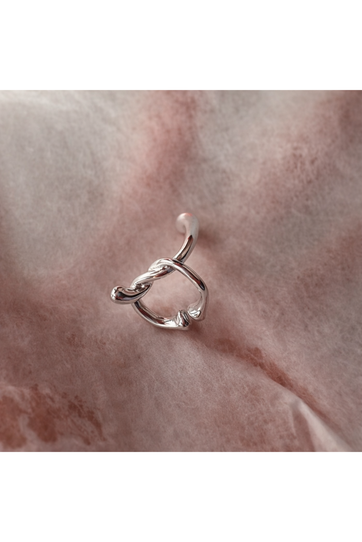A bold silver ear cuff styled as a single statement piece