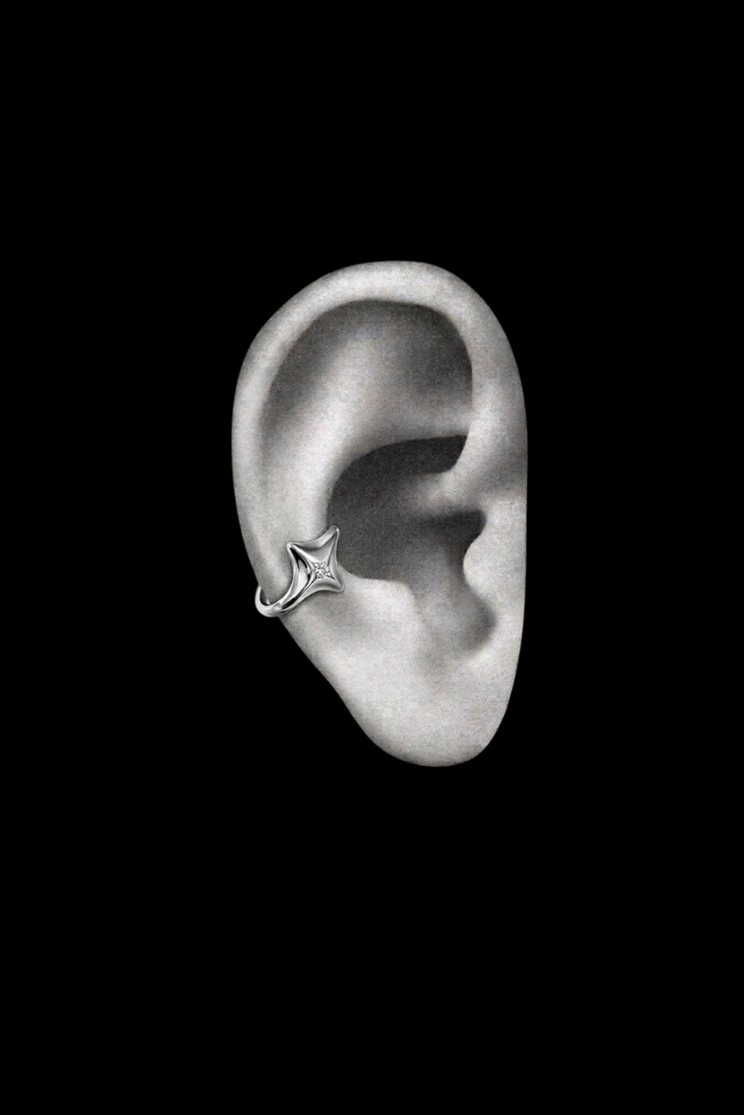 A small silver ear cuff with sparkling stones, clipped on the ear