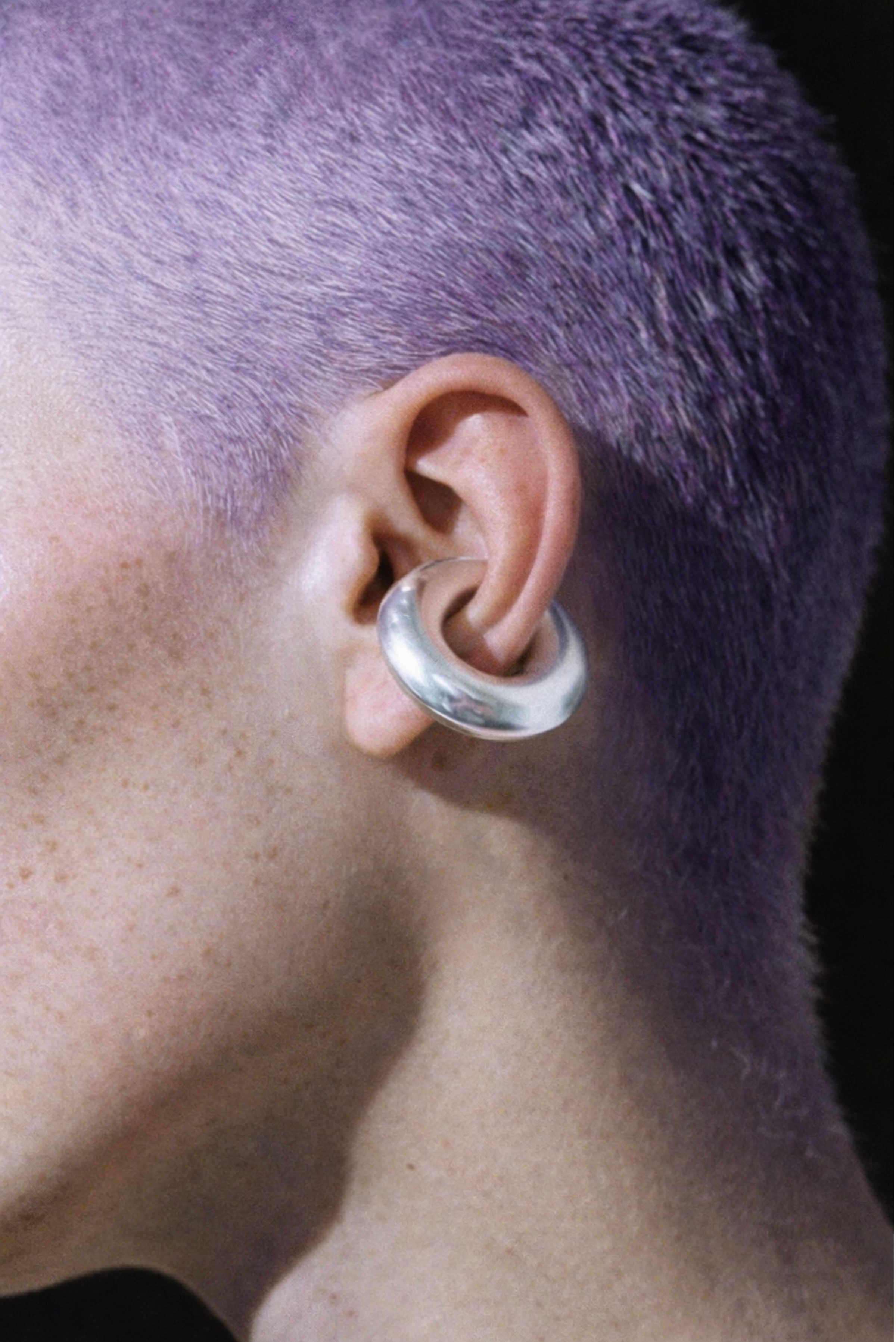 A model wearing an open-hoop ear cuff without a piercing