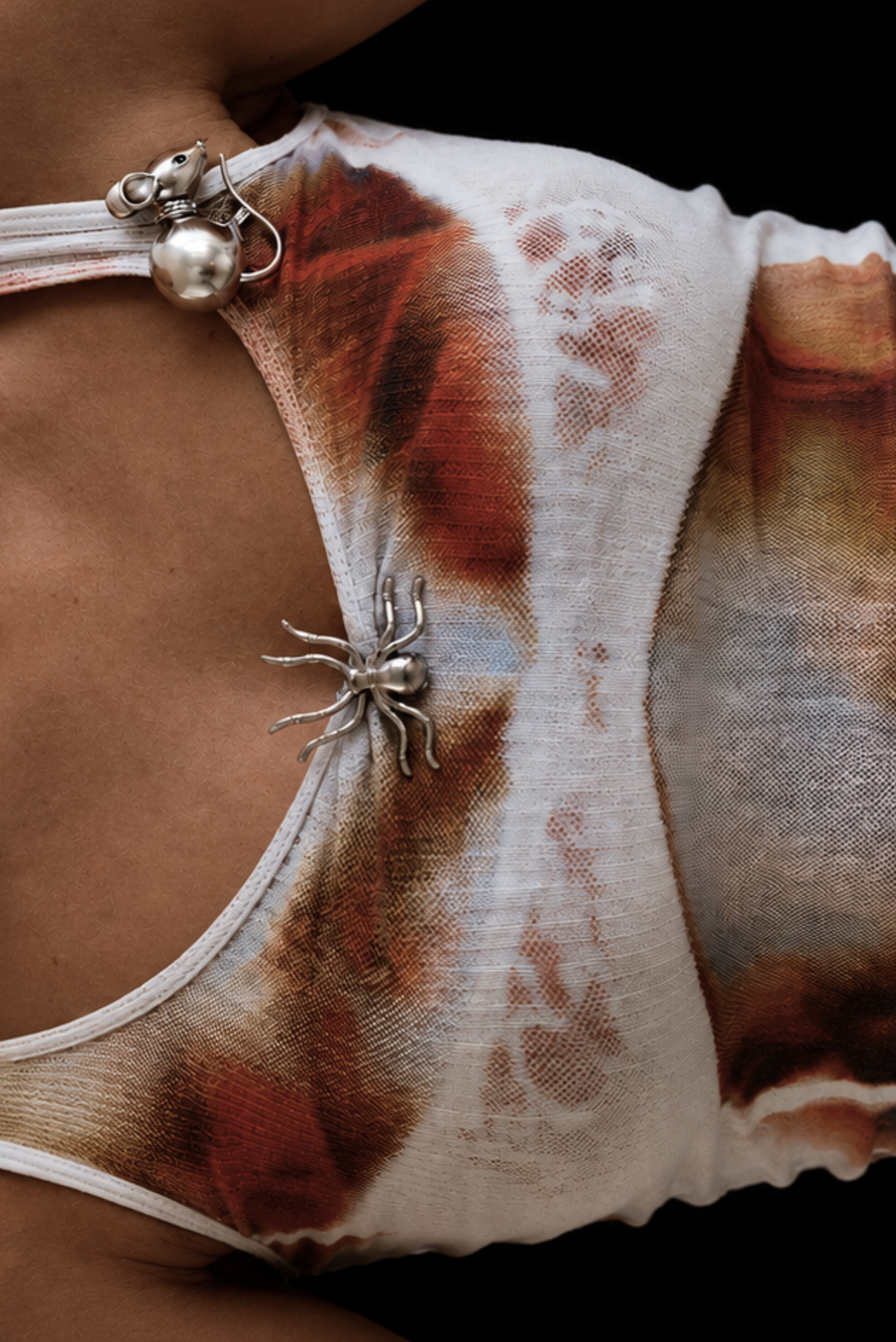 A gold spider-design pin fastened to fabric